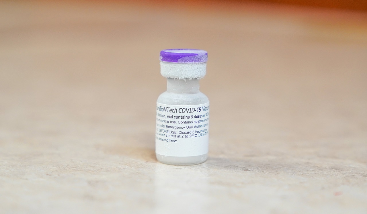 A vaccination record card and face mask on a table.