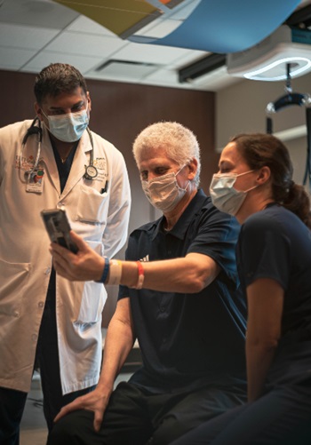 Phil Eaton with his doctor and physical therapist during rehabilitation