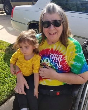 Susan Slovak, a TIRR Memorial Hermann patient, smiles while holding a child in her arms.