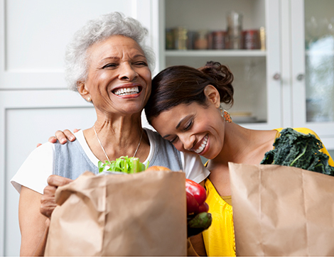 Mature mother and daughter with fresh groceries