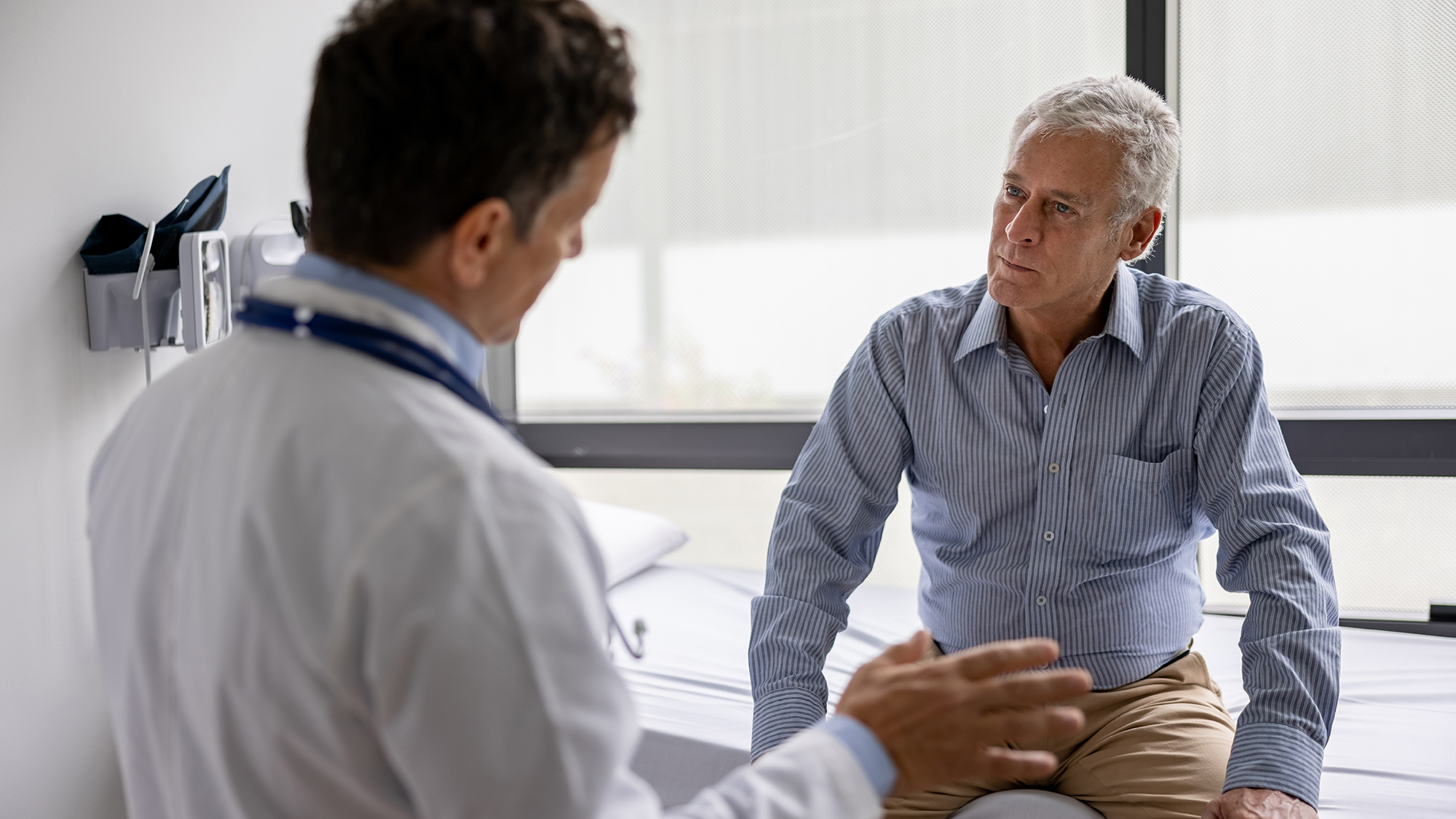 Male doctor speaking to man