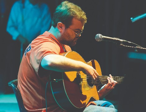 Former patient at TIRR Memorial Hermann, Brando Ray, plays guitar on stage.