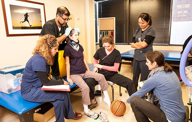 Woman going through rehabilitation with therapists