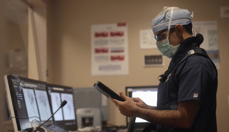 A physician looks at a tablet.