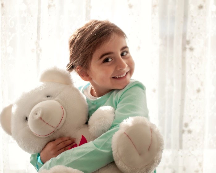 Child smiling with teddy bear