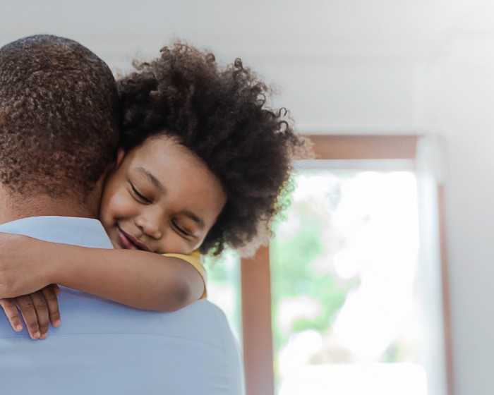 child smiling and hugging father