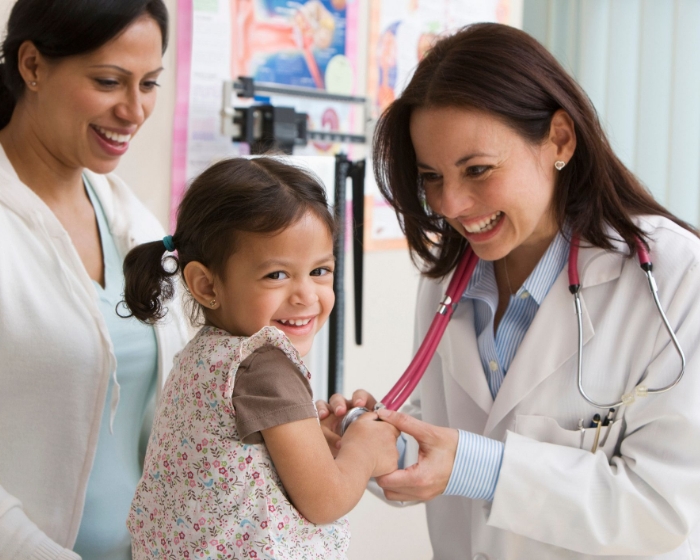patient smiling with parent and doctor