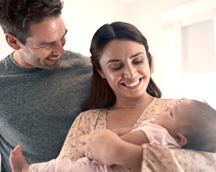 family smiling with baby