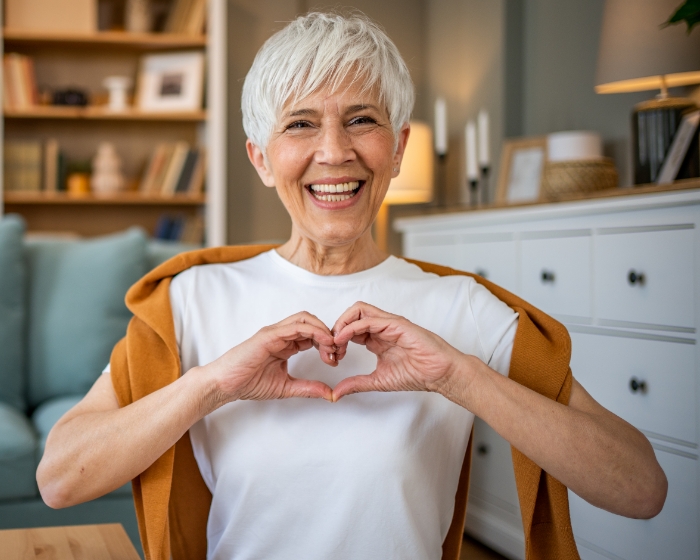 Older woman making heart with hands
