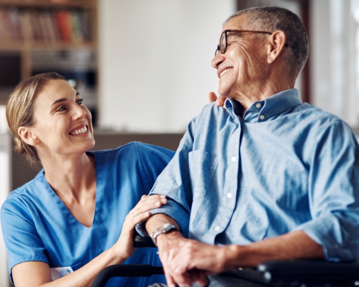 A clinical professional speaks to a patient in his home.