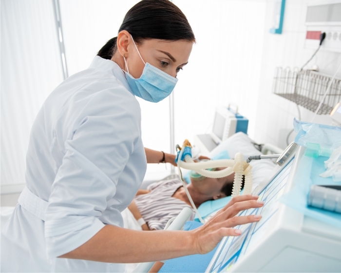 Masked physician checking patient with breathing device