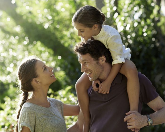 family smiling outdoors