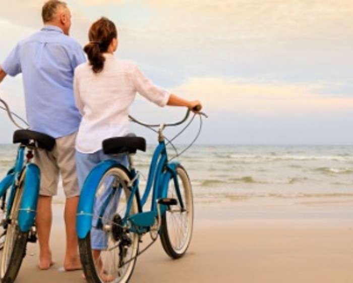 couple riding bikes on beach
