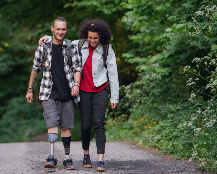 Two friends walk through nature, hugging and talking. 
