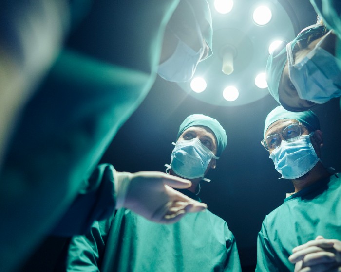 Surgeons under surgical lighting 