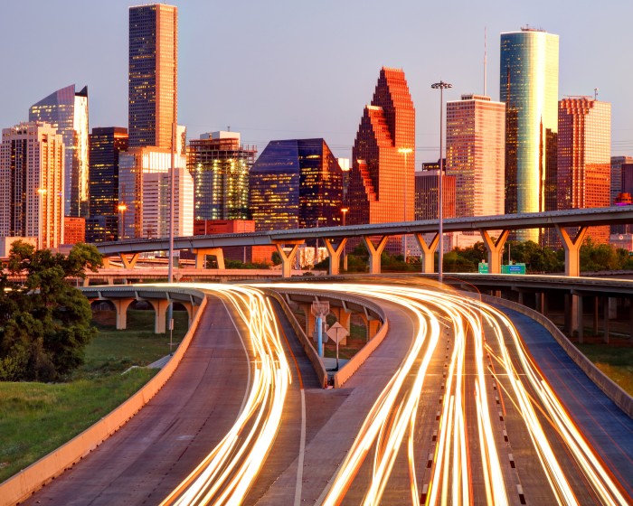 Houston, Texas skyline at dusk, showcasing the lights of cars in motion.